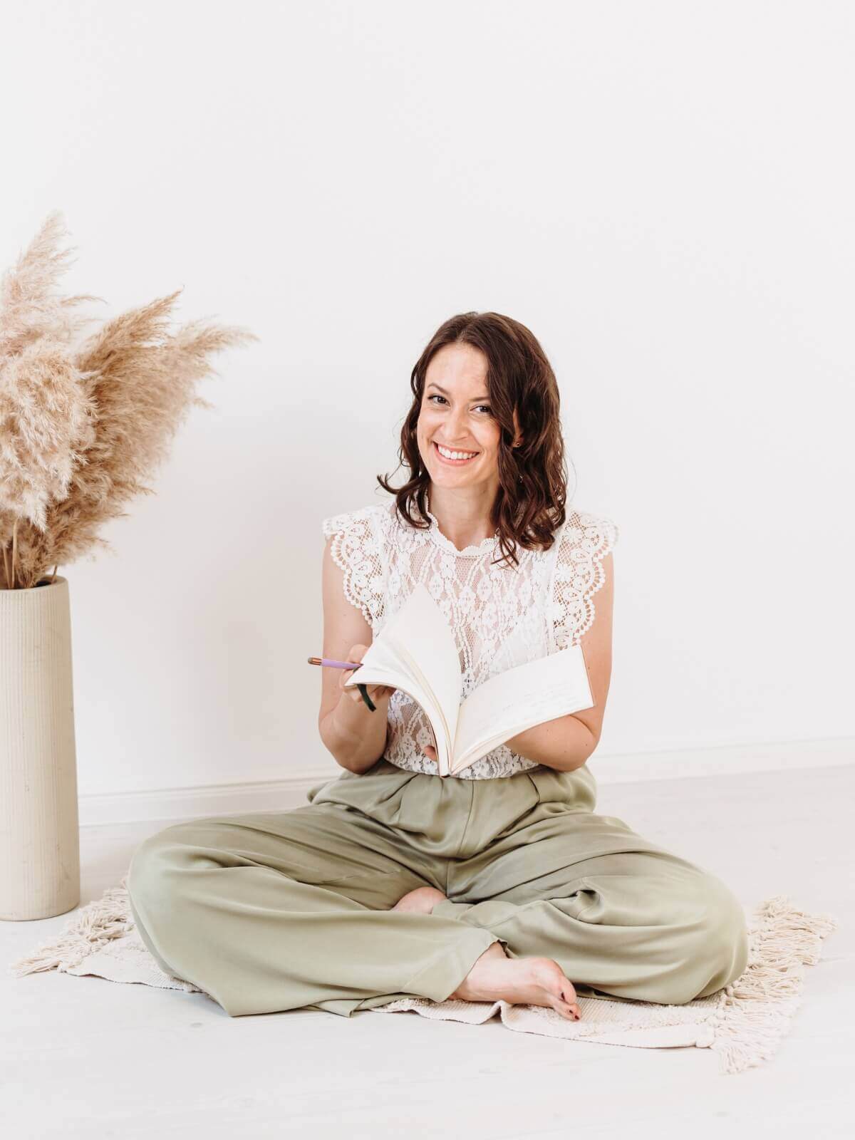 Steph sitzt auf Boden und blättert in Journal